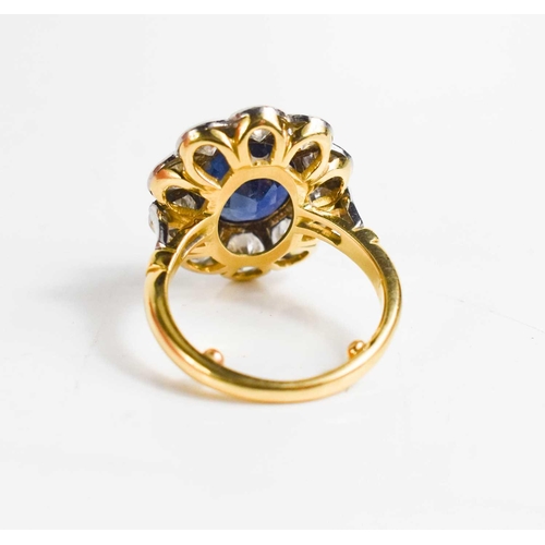 299 - An 18ct yellow gold, sapphire and diamond ring, the central oval cut deep cornflower blue sapphire o... 