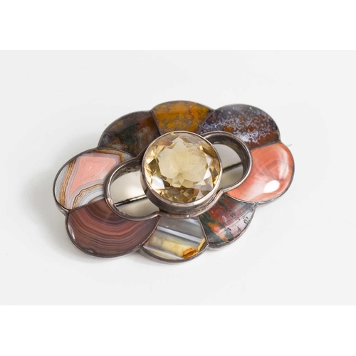 30 - A Scottish silver, agate and pale quartz brooch, the circular cut quartz bordered by various specime... 