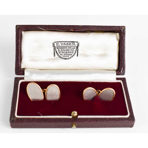 5 - A pair of 18ct yellow and white gold cufflinks, of oval form, with machine engraved decoration, in t... 