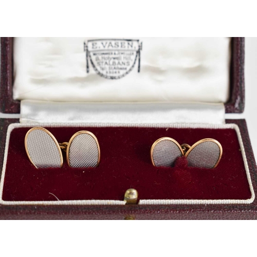 5 - A pair of 18ct yellow and white gold cufflinks, of oval form, with machine engraved decoration, in t... 