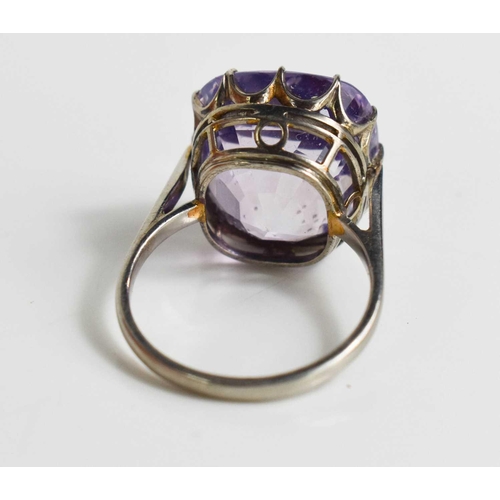 52 - A white metal (likely platinum) and pale lilac sapphire ring, the cushion cut lilac coloured sapphir... 