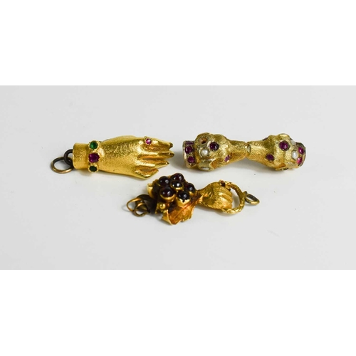 56 - Two gold (tested as) clasps in the form of hands, set with stones together with a gilt metal example... 