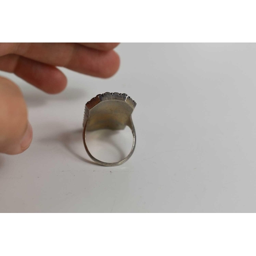 59 - A Victorian white metal and paste mourning ring with an enamelled centre depicting a woman beside do... 