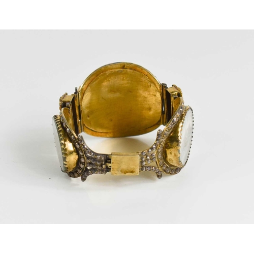 77 - A 19th century silver gilt Indian bangle, composed of three miniature figural landscapes, 2.53g