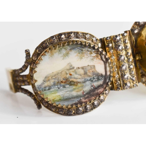 77 - A 19th century silver gilt Indian bangle, composed of three miniature figural landscapes, 2.53g