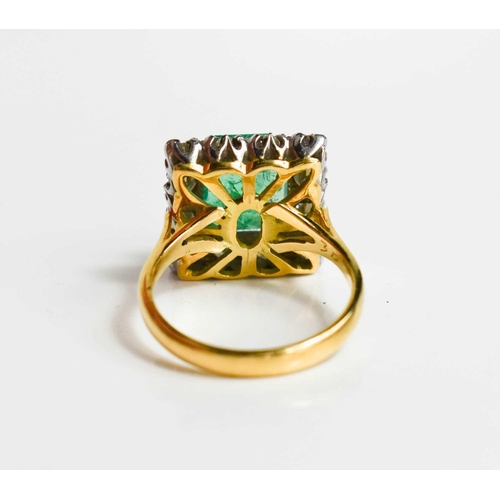 8 - An 18ct yellow gold, emerald and diamond ring, the cushion cut emerald bordered by twelve brilliant ... 