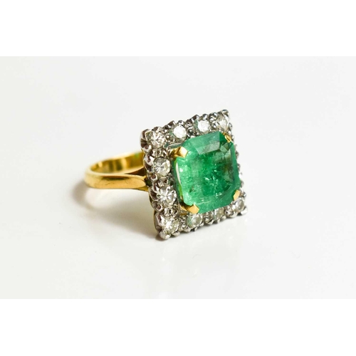 8 - An 18ct yellow gold, emerald and diamond ring, the cushion cut emerald bordered by twelve brilliant ... 