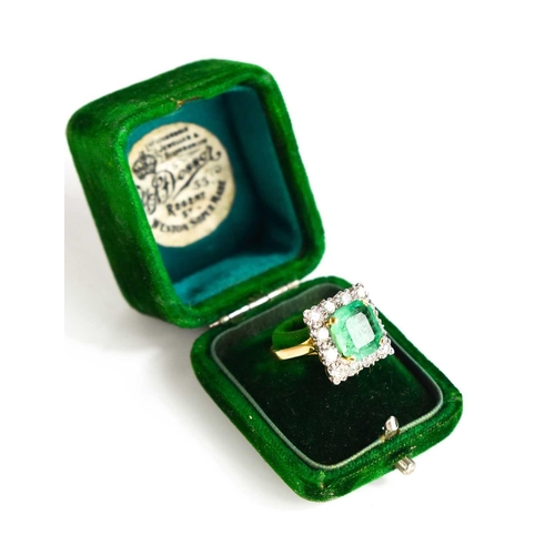 8 - An 18ct yellow gold, emerald and diamond ring, the cushion cut emerald bordered by twelve brilliant ... 