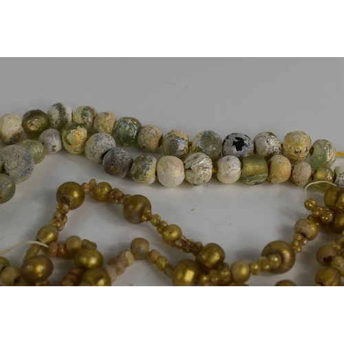 81 - A Roman glass bead necklace, circa 2nd/3rd Century A.D, the beads of various globular form, some wit... 