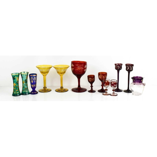 134 - A group of coloured bohemian glassware, to include pair of green and gilded bud vases, red painted g... 