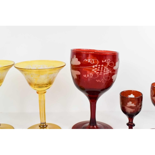 134 - A group of coloured bohemian glassware, to include pair of green and gilded bud vases, red painted g... 