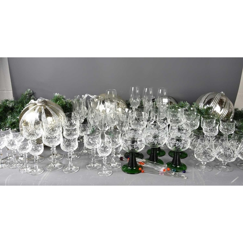 137 - A large group of crystal glass ware and other glasses to include green spiral stem wine glasses.