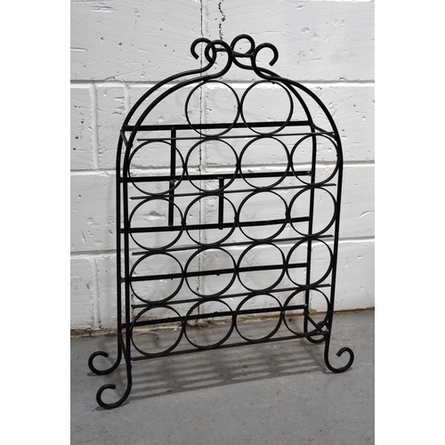 148 - A wrought iron wine rack for eighteen bottles raised on scroll feet.