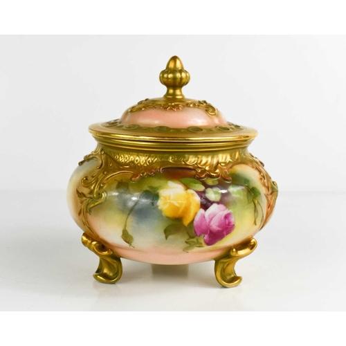 100 - A Royal Worcester pot pourri vase and cover, painted with roses, raised on three feet, 13cm high.The... 