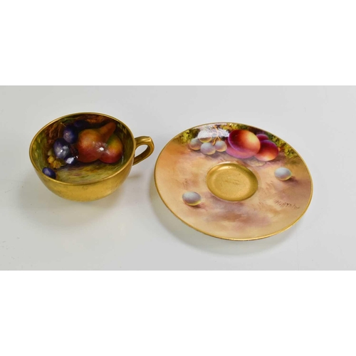 103 - A Royal Worcester miniature cup and saucer, painted with fruit to a mossy ground, the saucer signed ... 