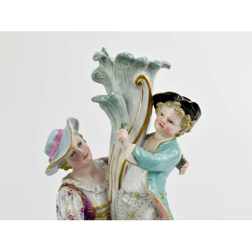 105 - A late 19th century Meissen porcelain figure group of mother and child, standing on her lap holding ... 