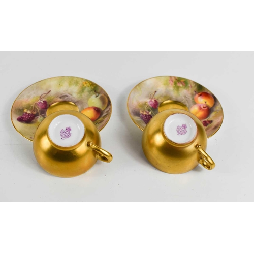 131 - A pair of Royal Worcester miniature cups and saucers, painted with fruits to mossy ground, puce mark... 