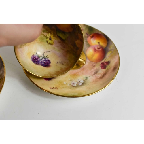 131 - A pair of Royal Worcester miniature cups and saucers, painted with fruits to mossy ground, puce mark... 