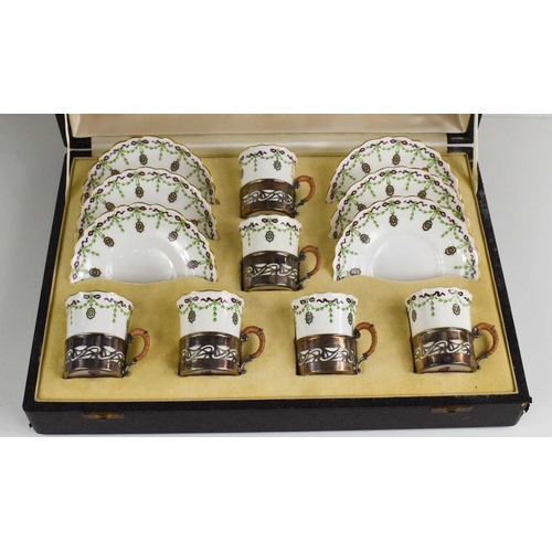 135 - A cased set of Royal Worcester coffee cans and saucers, puce mark 1900, decorated with green and puc... 