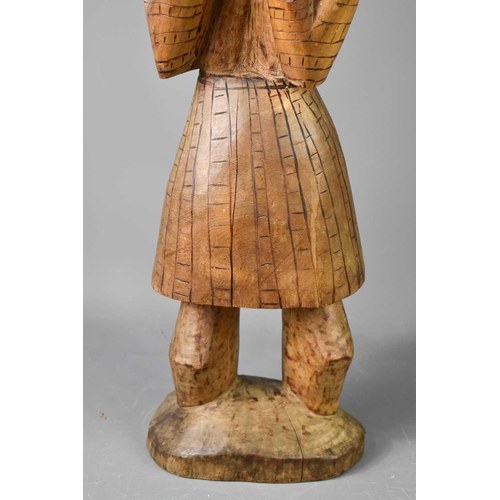 240 - A large carved African figure of a woman, possibly Tswana, with hands raised, with carved decoration... 