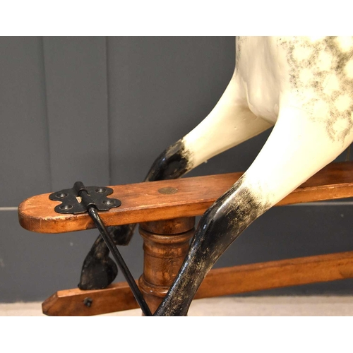 285 - A vintage rocking horse on a pine stained base. the dapple grey hand painted horse with leather sadd... 