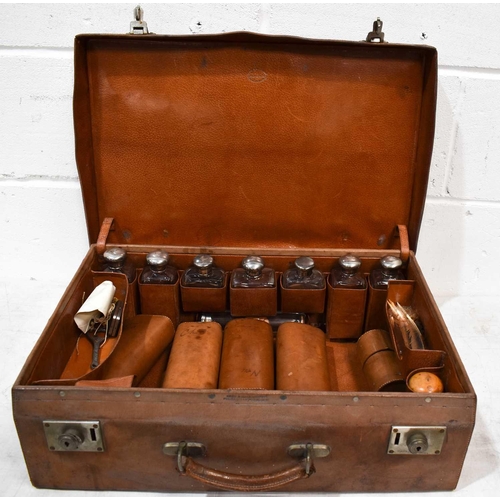 393 - A 19th century gentleman's travelling suitcase, containing eight silver bottles, London 1907, in bro... 