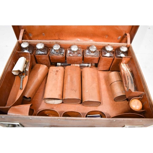 393 - A 19th century gentleman's travelling suitcase, containing eight silver bottles, London 1907, in bro... 