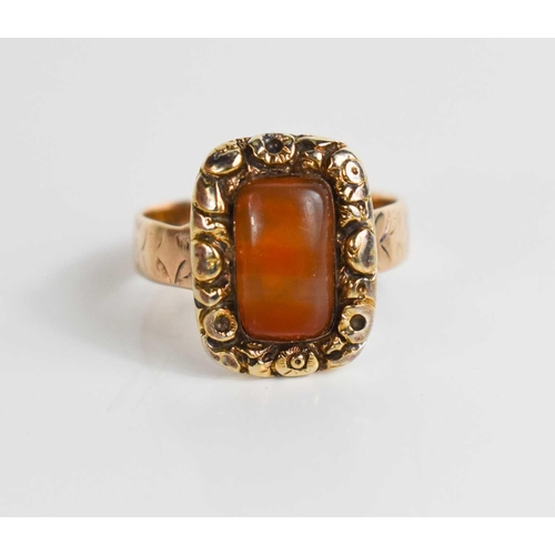 41 - A 12ct gold Georgian ring, set with an agate cabochon bordered by floral worked setting, on an engra... 