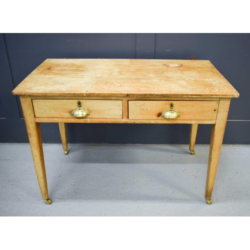 546 - An antique pine two drawer side table, with brass cup handles.