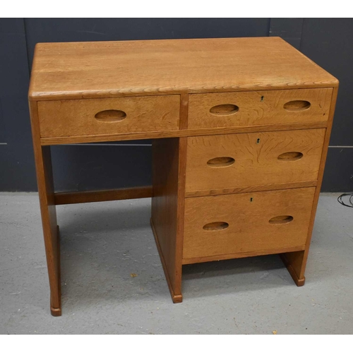 551 - A small Heals oak desk, composed of a bank of four short drawers.