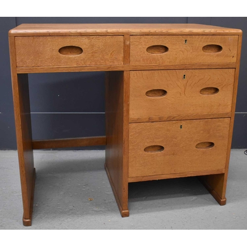 551 - A small Heals oak desk, composed of a bank of four short drawers.