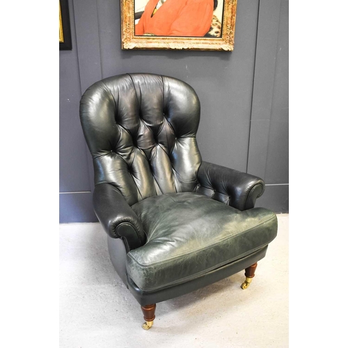 561 - A green leather button back armchair, with turned mahogany legs and brass castors.