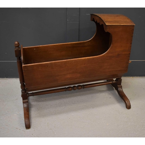 565 - A 19th century mahogany childrens cradle, with canopy hood, and raised on shaped feet, rocks from si... 