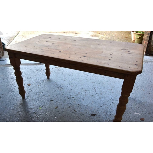 567 - A pine dining table with rectangular top and turned legs, 77cm by 148cm by 84cm.