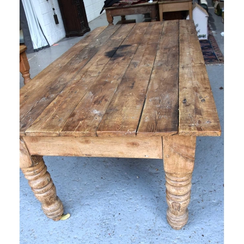 577 - A antique pine kitchen / dining table with seven plank top above large turned legs, 76cm by 214cm by... 