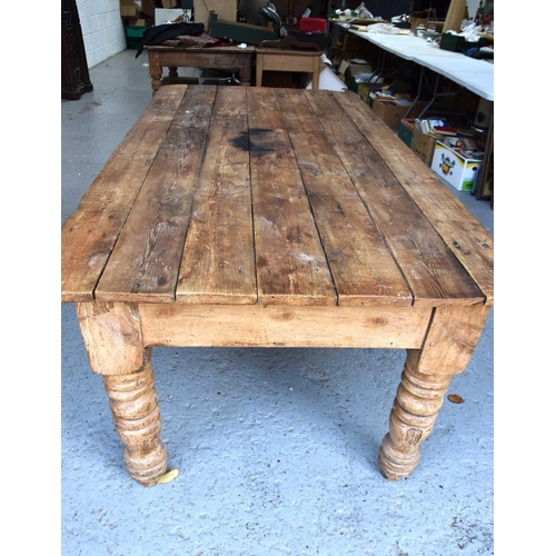 577 - A antique pine kitchen / dining table with seven plank top above large turned legs, 76cm by 214cm by... 