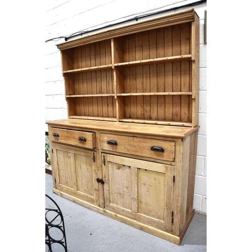 578 - A large antique pine dresser and rack, the enclosed rack having two shelves bearing cup hooks and pl... 