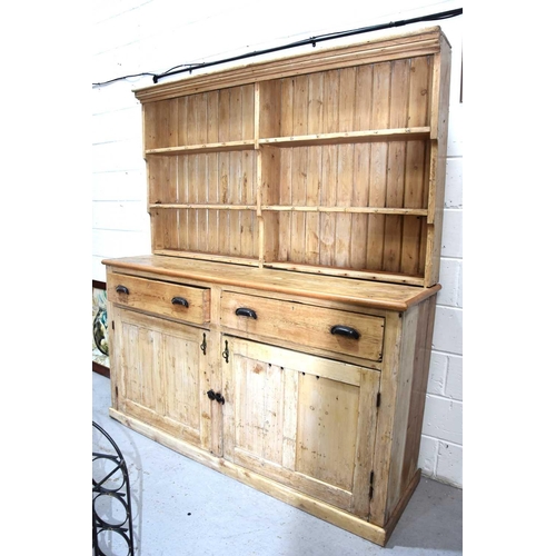 578 - A large antique pine dresser and rack, the enclosed rack having two shelves bearing cup hooks and pl... 