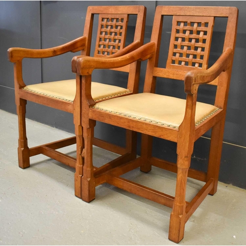 587 - A pair of Rabbit Man adzed oak carver chairs, with lattice backs, with downswept arms and leather pa... 