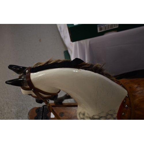 285 - A vintage rocking horse on a pine stained base. the dapple grey hand painted horse with leather sadd... 