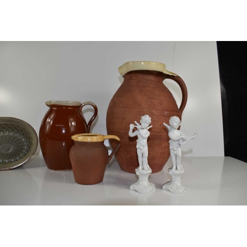 134 - A group of three stoneware jugs, three moulds and a set of four blanc de chine cherub musicians.