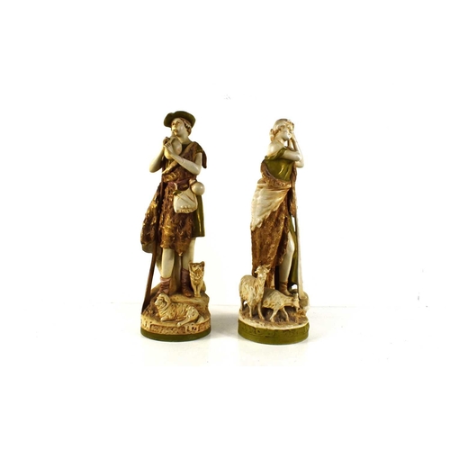 138 - A pair of early 20th century Royal Dux figures of a shepherd and shepherdess, he playing a pipe, and... 