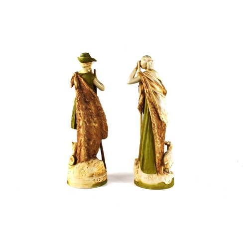 138 - A pair of early 20th century Royal Dux figures of a shepherd and shepherdess, he playing a pipe, and... 