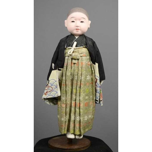 260 - An Ichimatsu doll, c.1960s, wearing hakama and haori, 49cm long. [Ichimatsu dolls are named after a ... 