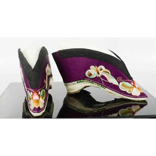 278 - A pair of Chinese silk lotus shoes, circa 1920, the purple silk embroidered to depict butterflies, 1... 