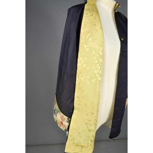 288 - A Chinese silk ladies jacket in dark blue, with yellow lining, the sleeve panels embroidered with pe... 