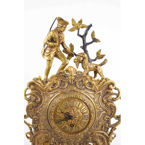 299 - A 19th century gilt brass mantle clock, the decoratively cast body surmounted by a huntsman with his... 