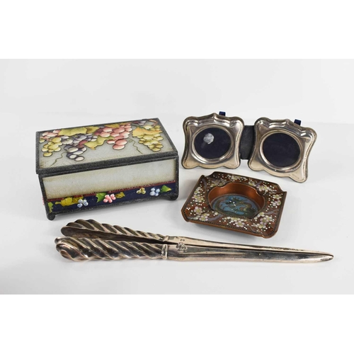 319 - A silver folding travel picture frame, a pair of silver glove stretchers, a cloisonne Chinese ashtra... 