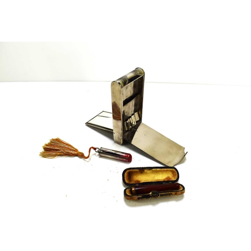 322 - An Art Deco metal cigarette case and compact with a mirror and pull-out lipstick, along with Bakelit... 