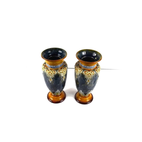 33 - A pair of Doulton Lambeth vases, with mottled blue ground embossed with anthemion motifs, signed to ... 